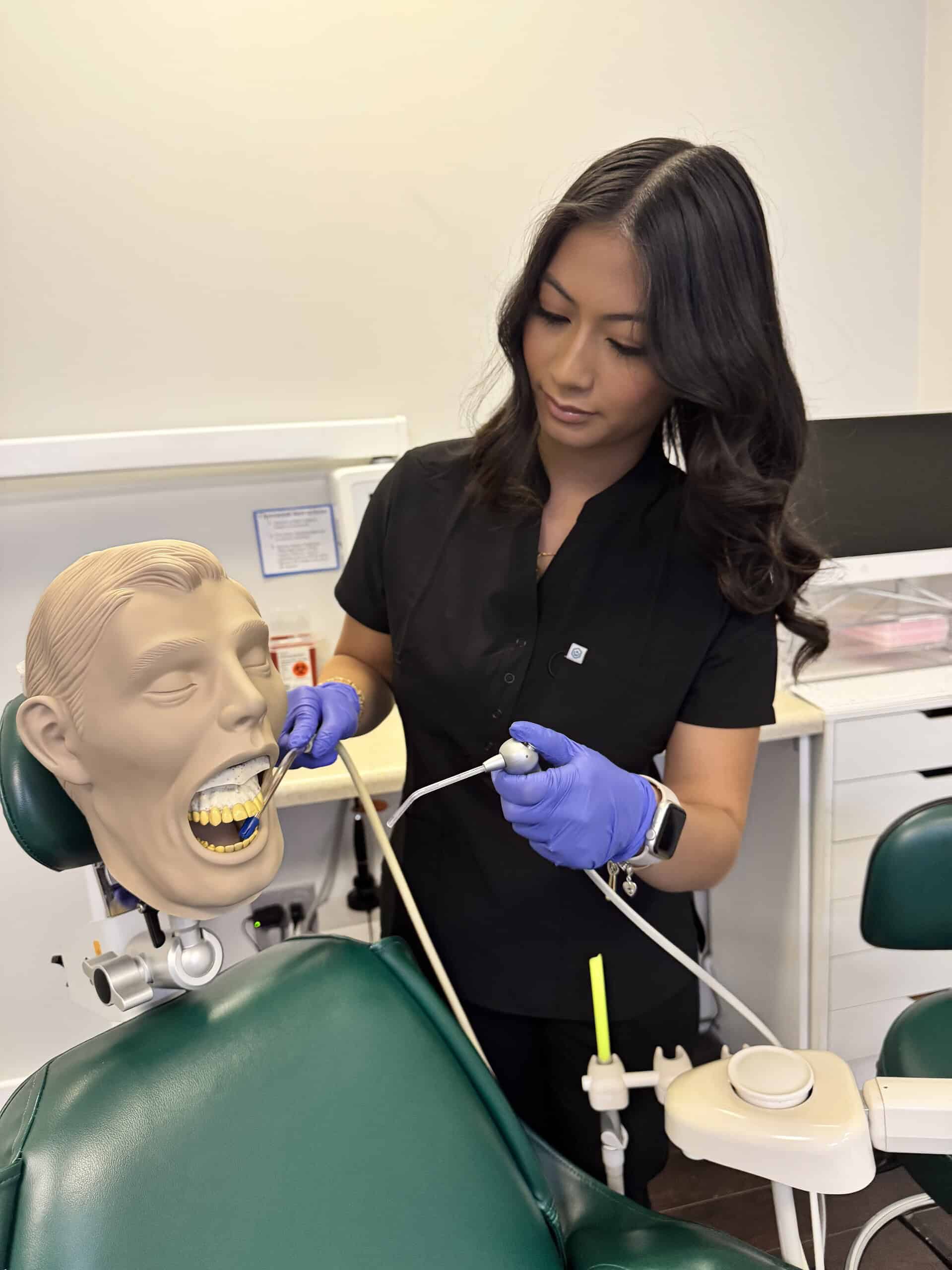 Estudiante practicando técnicas de asistencia dental en un entorno clínico de entrenamiento